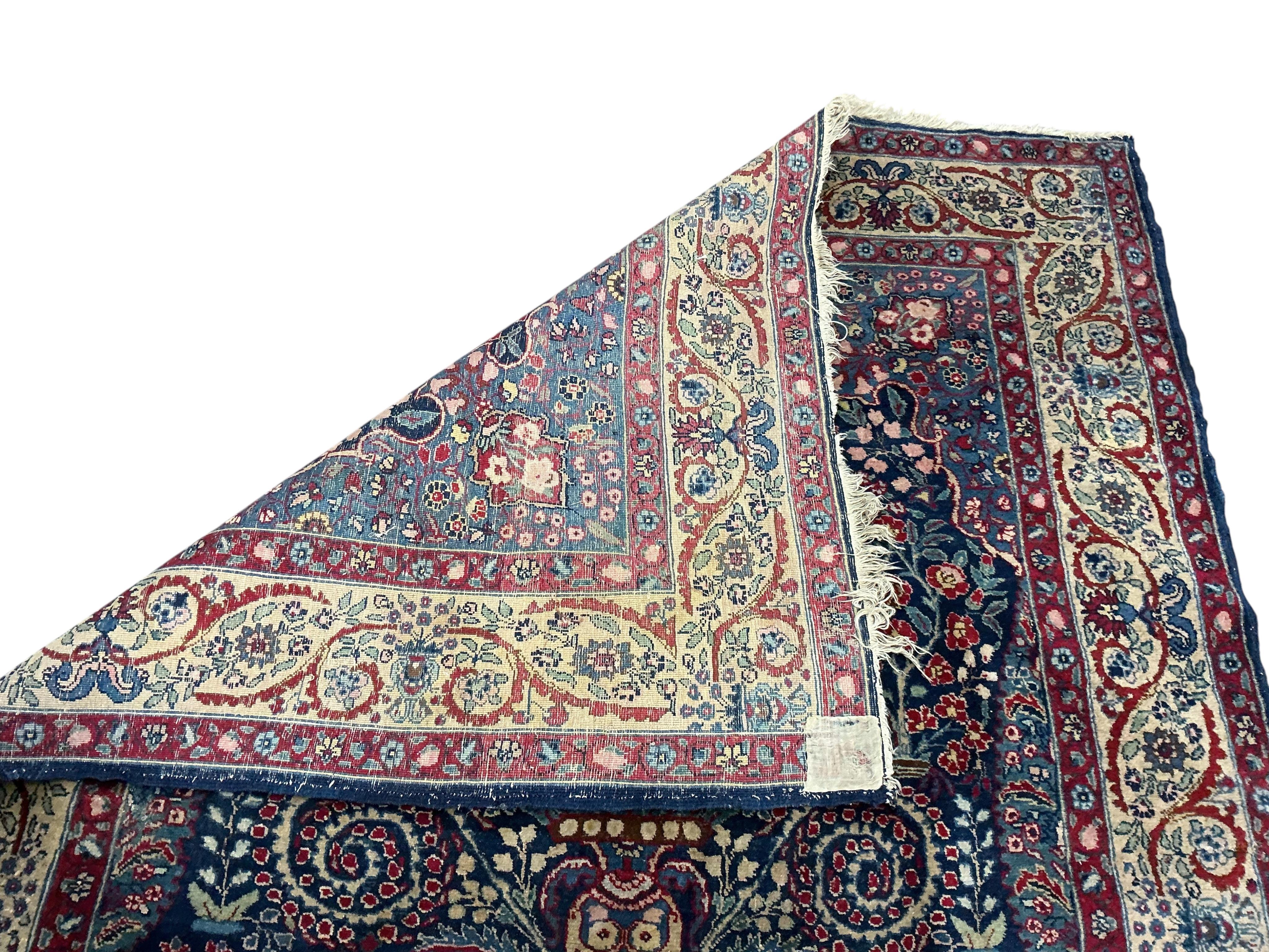 An early 20th century Persian Kashan prayer rug, the central blue ground field with a flower vase within multiple borders, 189 x 145cm
